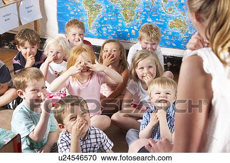 Stock Image - Montessori/Pre-School Class Listening to Teacher on Carpet. Fotosearch