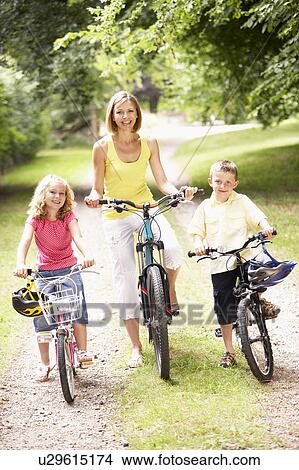 Mother and children riding bikes in countryside View Large Photo Image Picture - Mother and children riding bikes in countryside. Fotosearch