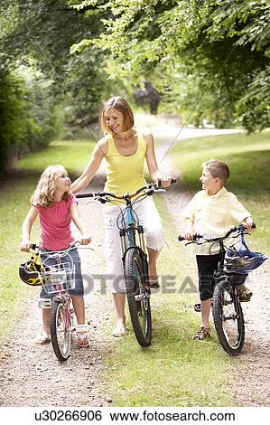 Mother and children riding bikes in countryside View Large Photo Image Stock Photograph - Mother and children riding bikes in countryside. Fotosearch