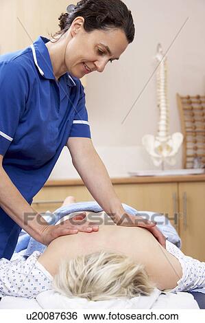 Osteopath treating female client View Large Photo Image Stock Photograph - Osteopath treating female client. Fotosearch