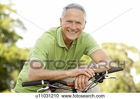 Portrait of man riding cycle in countryside View Large Photo Image Stock Image - Portrait of man riding cycle in countryside. Fotosearch