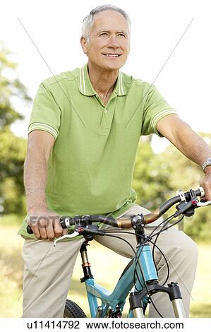 Portrait of man riding cycle in countryside View Large Photo Image Stock Image - Portrait of man riding cycle in countryside. Fotosearch
