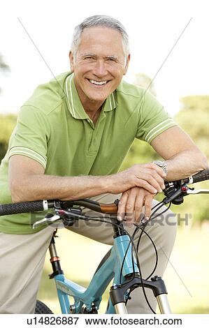 Portrait of man riding cycle in countryside View Large Photo Image Stock Photo - Portrait of man riding cycle in countryside. Fotosearch