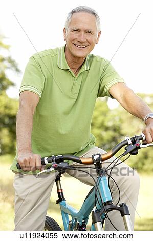 Portrait of man riding cycle in countryside View Large Photo Image Stock Photography - Portrait of man riding cycle in countryside. Fotosearch