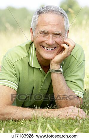 Stock Photograph - Portrait of mature man relaxing in countryside. Fotosearch