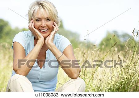 Portrait of mature woman sitting in countryside View Large Photo Image Stock Image - Portrait of mature woman sitting in countryside. Fotosearch