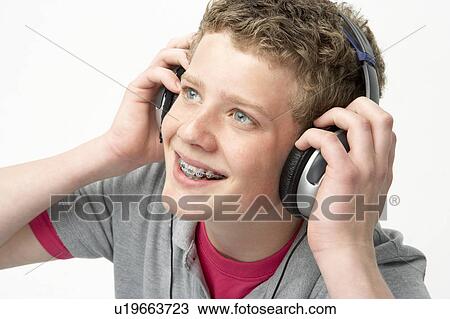 Stock Image - Portrait of Smiling Teenage Boy Listening to Music. Fotosearch
