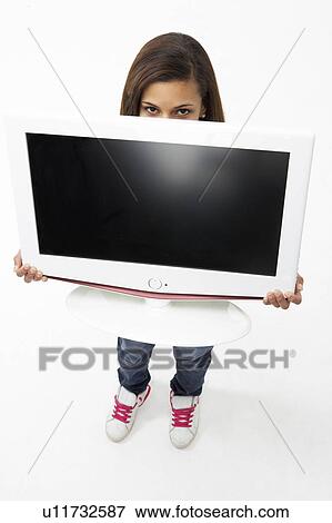 Stock Photo - Portrait of Smiling Teenage Girl Holding Television. Fotosearch