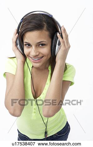Stock Photo - Portrait of Smiling Teenage Girl Listening to Music. Fotosearch