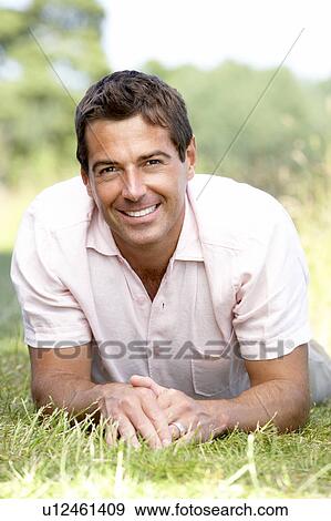 Portrait of young man relaxing in countryside View Large Photo Image Stock Photo - Portrait of young man relaxing in countryside. Fotosearch
