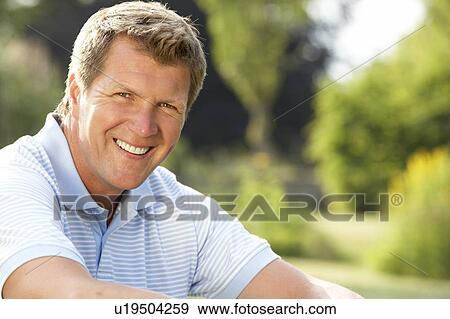 Stock Photo - Portrait of young man relaxing in countryside. Fotosearch