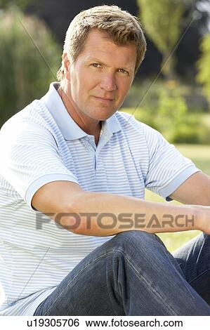 Portrait of young man relaxing in countryside View Large Photo Image Stock Photograph - Portrait of young man relaxing in countryside. Fotosearch