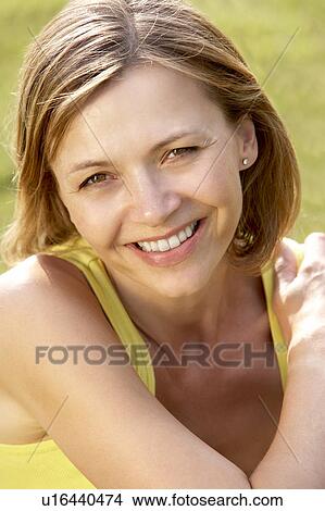 Picture - Portrait of young woman relaxing in countryside. Fotosearch