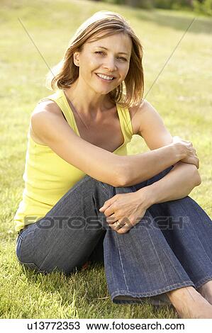 Portrait of young woman relaxing in countryside View Large Photo Image Stock Image - Portrait of young woman relaxing in countryside. Fotosearch