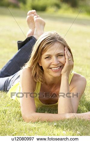 Portrait of young woman relaxing in countryside View Large Photo Image Stock Photo - Portrait of young woman relaxing in countryside. Fotosearch