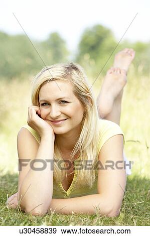 Stock Photo - Portrait of young woman relaxing in countryside. Fotosearch