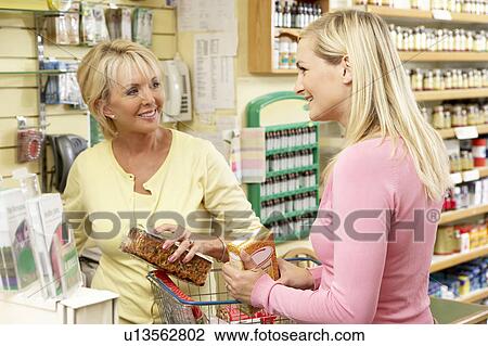 Sales assistant with customer in health food store View Large Photo Image Stock Image - Sales assistant with customer in health food store. Fotosearch