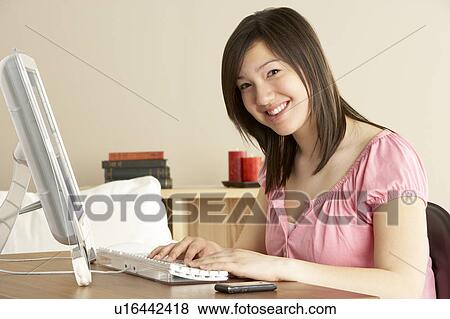 Smiling Teenage Girl on Computer at Home View Large Photo Image Stock Photo - Smiling Teenage Girl on Computer at Home. Fotosearch
