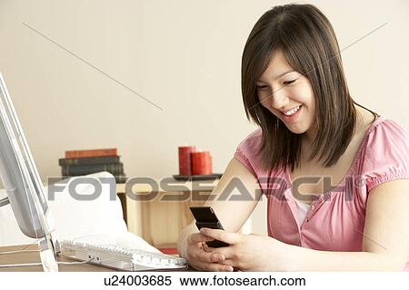 Smiling Teenage Girl using Mobile Phone at Home View Large Photo Image Stock Photography - Smiling Teenage Girl using Mobile Phone at Home. Fotosearch