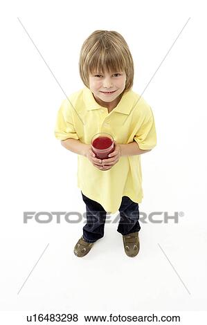 Stock Photo - Studio Portrait of Smiling Boy Holding Glass of Fruit Juice. Fotosearch