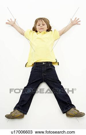 Studio Portrait of Smiling Boy lying down with arms and legs spread View Large Photo Image Stock Image - Studio Portrait of Smiling Boy lying down with arms and legs spread. Fotosearch