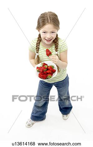 Stock Photo - Studio Portrait of Smiling Girl Holding Bowl of Strawberries. Fotosearch