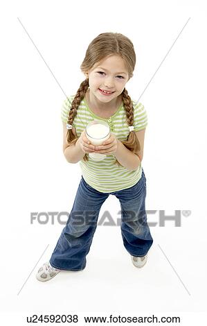 Stock Photo - Studio Portrait of Smiling Girl Holding Glass of Milk. Fotosearch