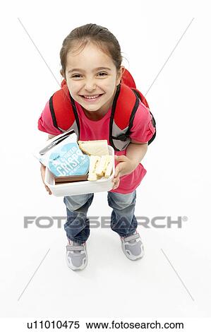 Stock Photography - Studio Portrait of Smiling Girl Holding Lunchbox. Fotosearch