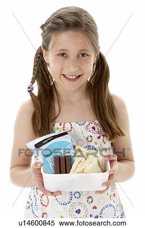 Stock Photography - Studio Portrait of Smiling Girl Holding Lunchbox. Fotosearch