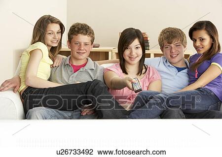 Stock Image - Teenage Friends Watching Television at Home. Fotosearch