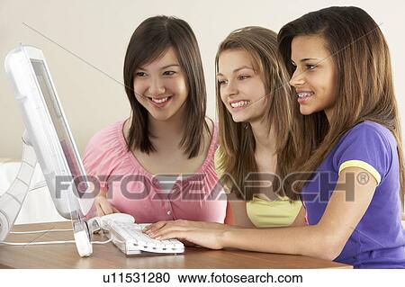 Stock Image - Teenage Girlfriends on Computer at Home. Fotosearch
