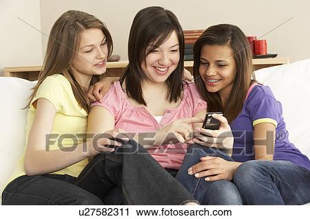 Teenage Girlfriends Reading Mobile Phone at Home View Large Photo Image Stock Image - Teenage Girlfriends Reading Mobile Phone at Home. Fotosearch