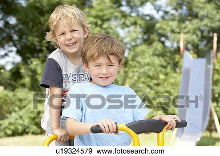 Two Young Boys Playing on Bike View Large Photo Image Stock Photo - Two Young Boys Playing on Bike. Fotosearch