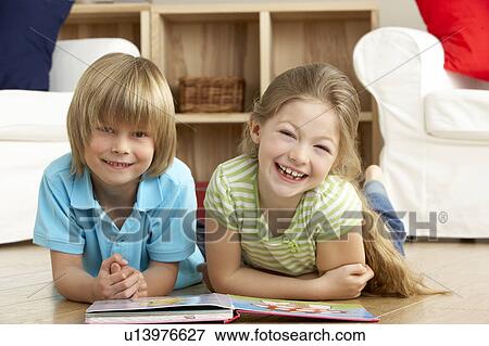 Two Young Children Reading Book at Home View Large Photo Image Stock Photo - Two Young Children Reading Book at Home. Fotosearch