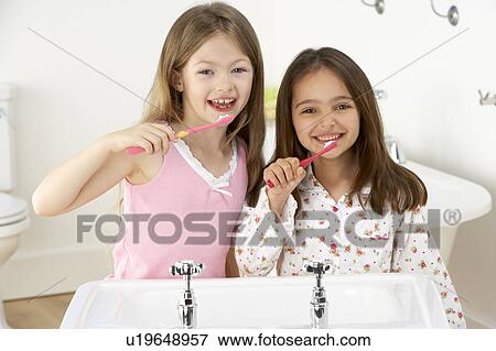Two Young Girls Brushing Teeth at Sink View Large Photo Image Stock Photo - Two Young Girls Brushing Teeth at Sink. Fotosearch