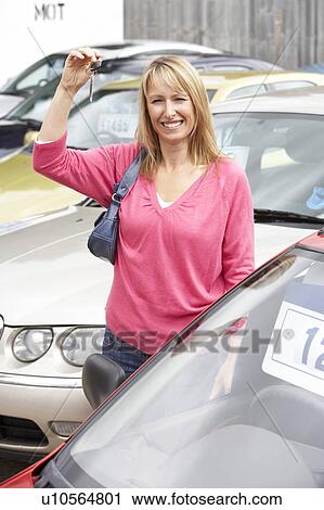 Stock Image - Woman collecting new car. Fotosearch