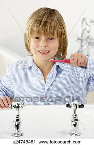 Stock Image - Young Boy Brushing Teeth at Sink. Fotosearch