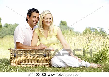 Young couple having picnic in countryside View Large Photo Image Stock Image - Young couple having picnic in countryside. Fotosearch