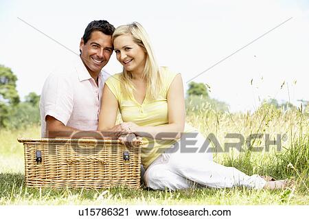 Young couple having picnic in countryside View Large Photo Image Stock Image - Young couple having picnic in countryside. Fotosearch
