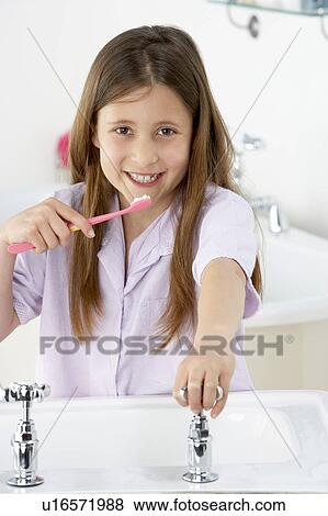 Stock Photo - Young Girl Brushing Teeth at Sink. Fotosearch
