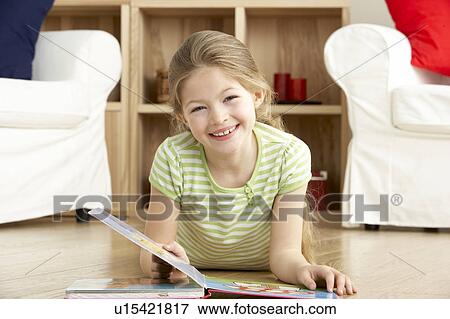 Stock Photo - Young Girl Reading Book at Home. Fotosearch