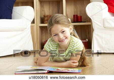 Stock Photograph - Young Girl Reading Book at Home. Fotosearch