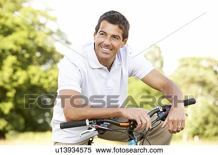 Young man riding bike in countryside View Large Photo Image Stock Photography - Young man riding bike in countryside. Fotosearch