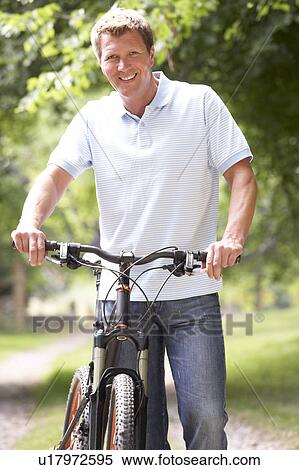 Young man riding bike in countryside View Large Photo Image Stock Photography - Young man riding bike in countryside. Fotosearch