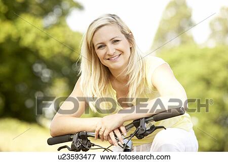 Young woman riding bike in countryside View Large Photo Image Stock Photo - Young woman riding bike in countryside. Fotosearch
