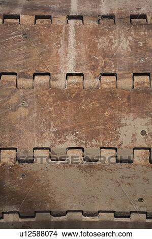 Picture - Close-up of a rusted steel track wheel on a excavator. Fotosearch
