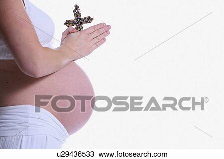 Pregnant woman praying with crucifix View Large Photo Image Stock Image - Pregnant woman praying with crucifix. Fotosearch
