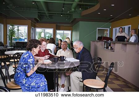 Stock Image - Seniors in restaurant. Fotosearch