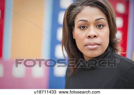 Stock Image - Woman standing in front of a city mural. Fotosearch