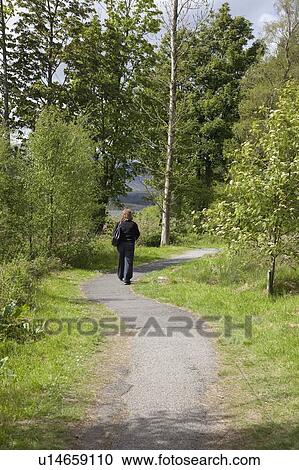 Woman walking on a path View Large Photo Image Stock Image - Woman walking on a path. Fotosearch